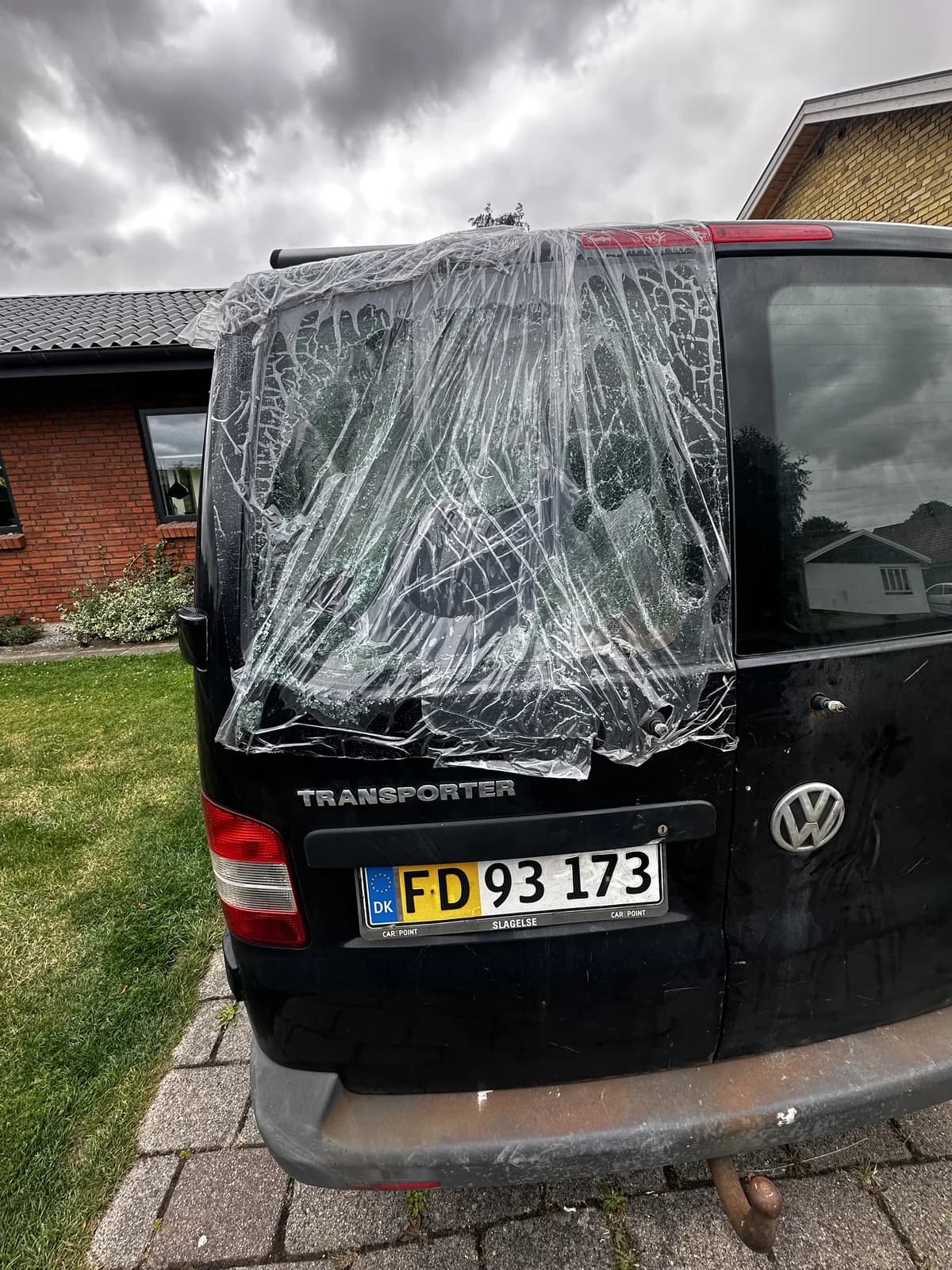 Knust bagrude på en VW Transporter, dækket med plast