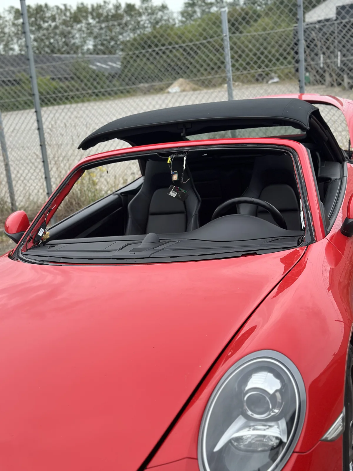 Rød Porsche med forruden afmonteret under rudeskift